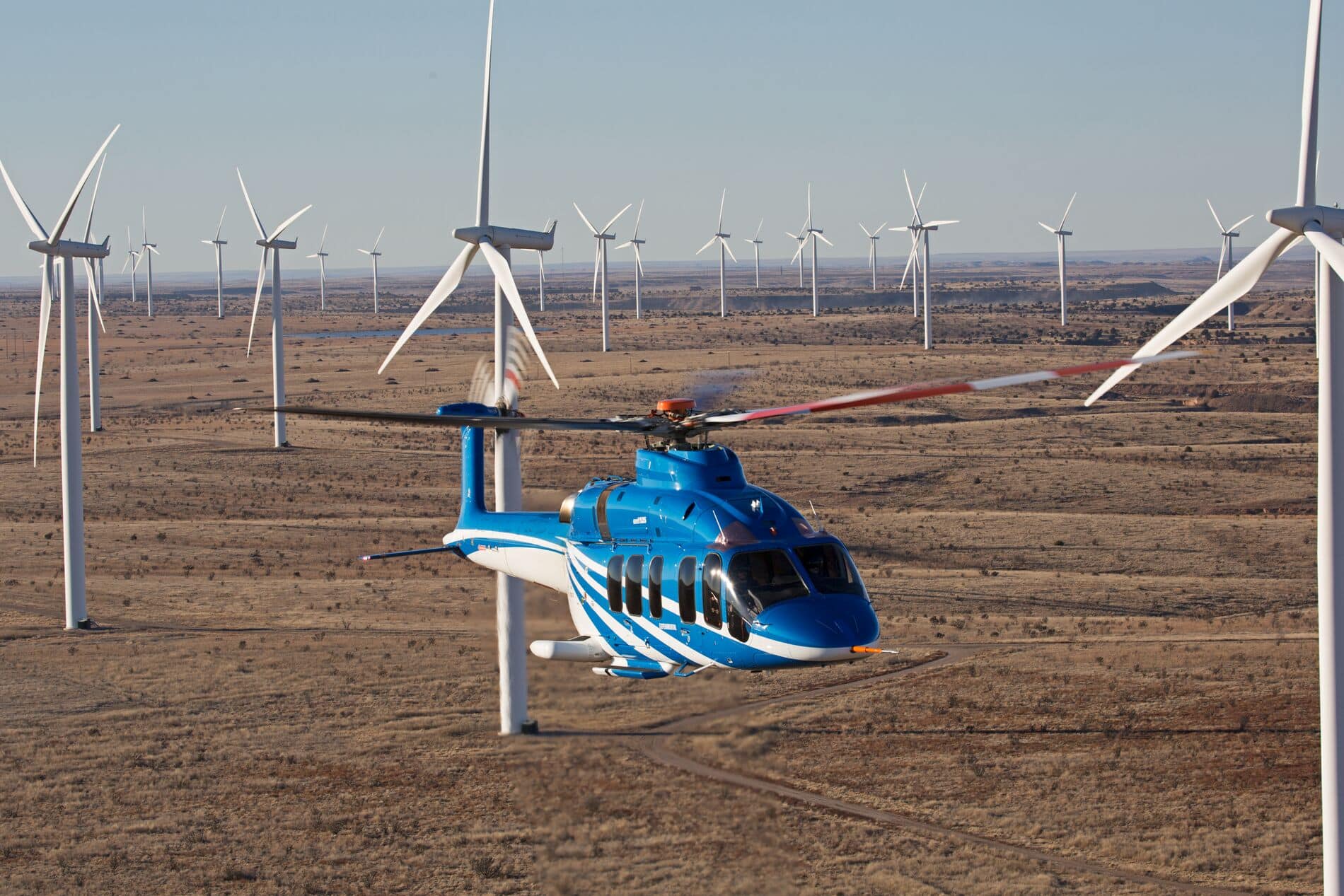 砂漠地帯の風力発電施設を通り抜けるBell 525